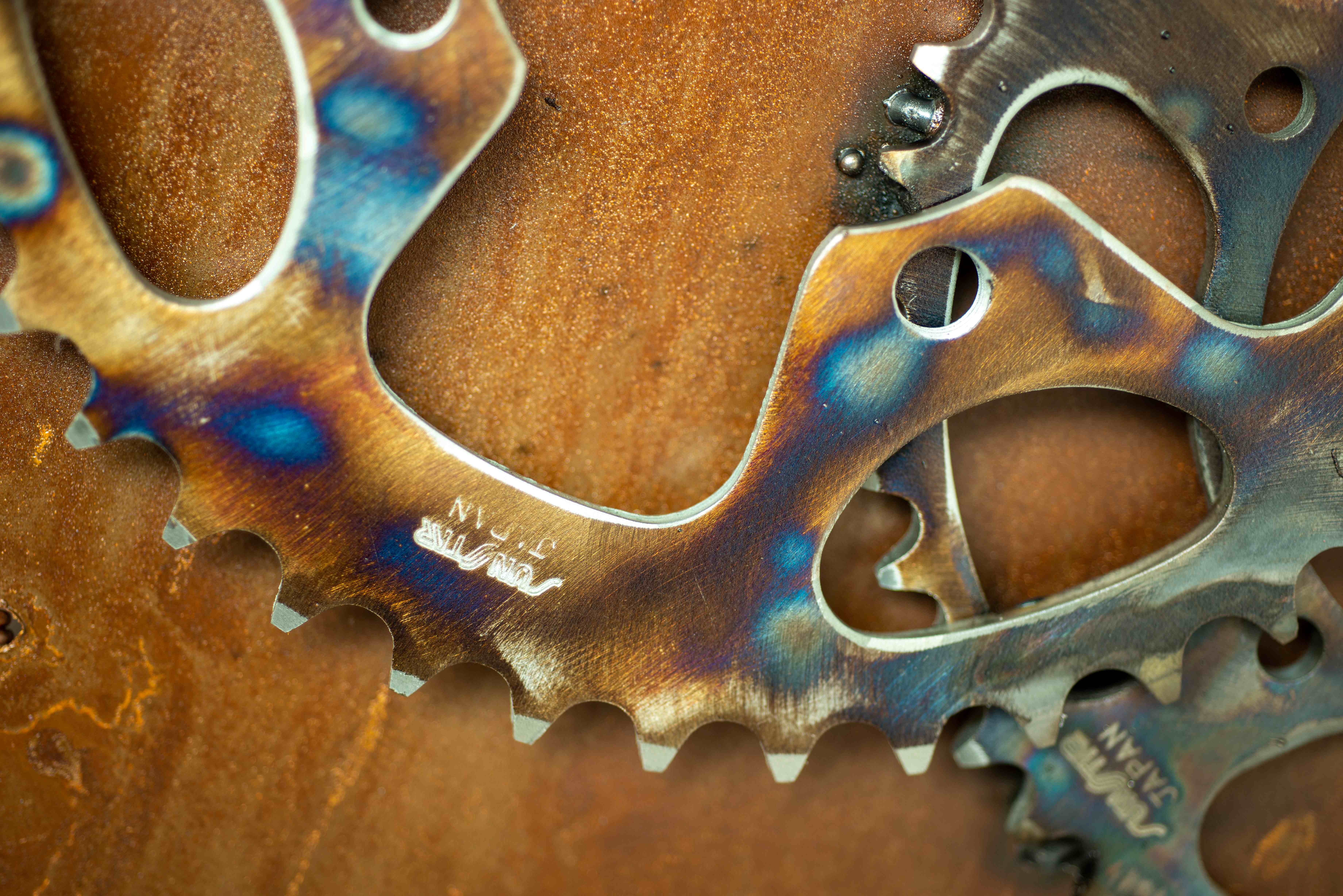 Heat-patinated metal gears showcasing copper and steel craftsmanship